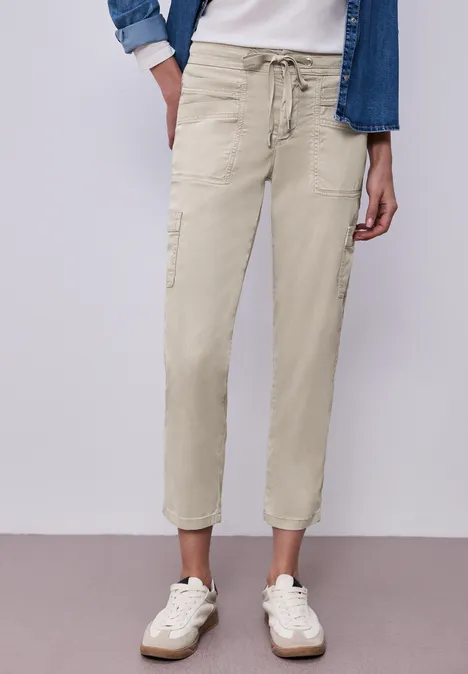 Cargo Joggpants buff grey Beige Cargo-Hose mit Tunnelzug, seitlichen Taschen und weißen Sneakern an neutraler Wand.