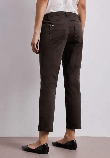 7/8 Slim Legs broek in satijnlook deep earth Achteraanzicht van een persoon met donkerbruine, enkellange broek en zwarte instappers.