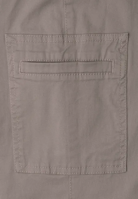 Chino's met Slim Legs en cargo-stijl zakken dark tumbled beige Close-up van een beige katoenen broek met opgestikte zak en subtiele sierstiksels.