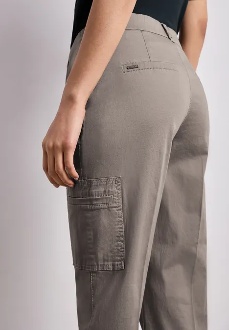 Chino's met Slim Legs en cargo-stijl zakken dark tumbled beige Zijaanzicht van een persoon in grijze cargobroek met zakken, gefocust op taille en benen.