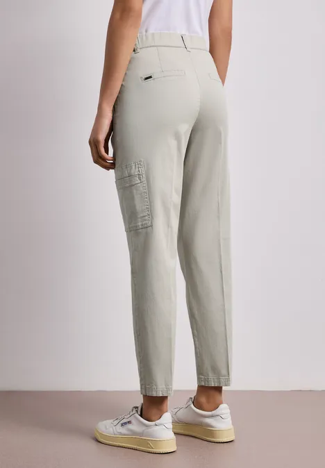 Chino's met Slim Legs en cargo-stijl zakken cobble stone Achteraanzicht van iemand in lichtgrijze cargobroek en witte sneakers.