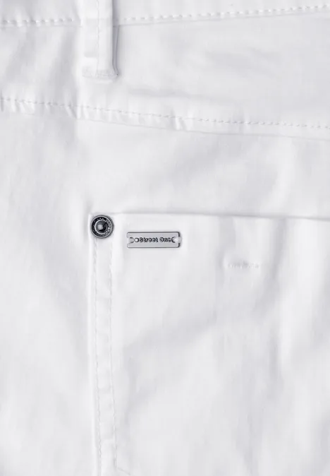 Naheaufnahme einer weißen Jeanshose mit aufgesetzter Tasche, Niete und kleinem Markenlabel.