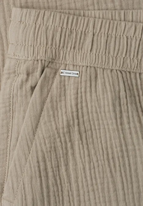Nahaufnahme beiger Cordhosen mit elastischem Bund, Tasche und kleinem Label