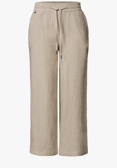 Beige Cordhose mit weitem Bein und Bindeband in der Taille.