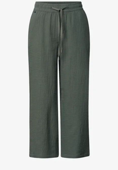 Donkergroene, wijdvallende broek van textuurstof met elastische taille en trekkoord.