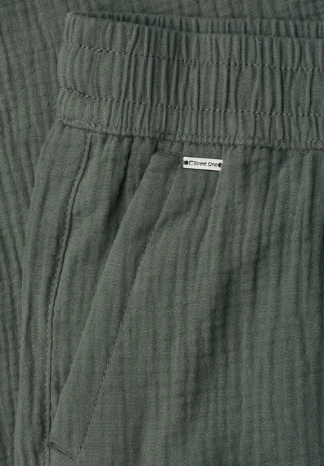 Donkergroene broek van licht gekreukt katoen met elastische taille en zijzak.