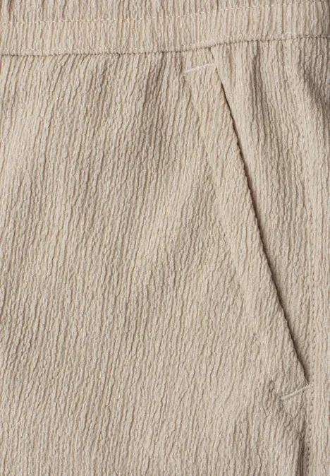 Beige Hose aus strukturierter Baumwollmischung mit elastischem Bund und seitlicher Tasche.