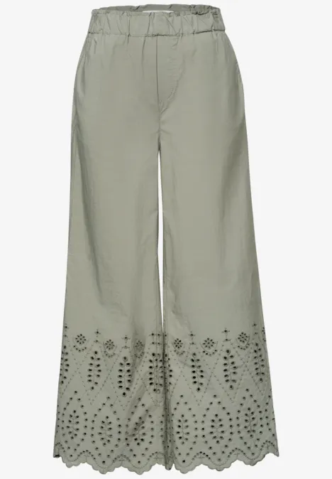 Wijd olijfgroen pantalon met elastische taille en bloemige laser-cut details aan de zoom.