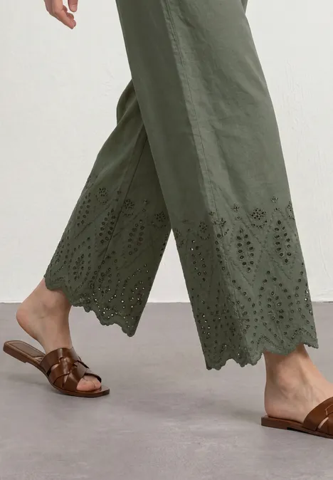 Pantalon large olive à bord festonné et broderie, sandales marron.