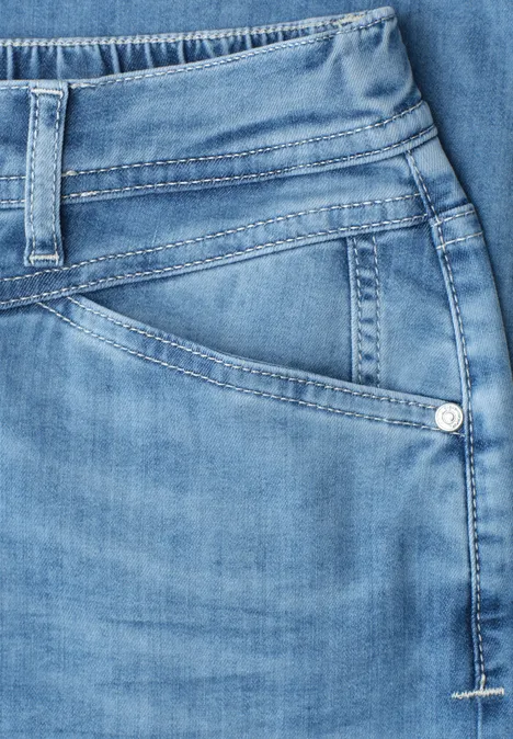 Nahaufnahme einer hellblauen Jeans-Tasche und Bund mit sichtbarer Naht und Gürtelschlaufe.