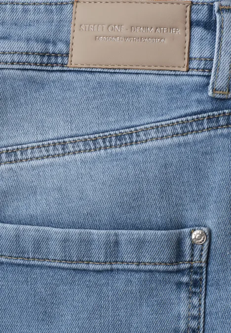 High Waist Barrel Leg Jeans im Loose Fit authentic light blue Nahaufnahme einer blauen Jeans mit Fronttasche, Metallniete und Lederetikett am Bund