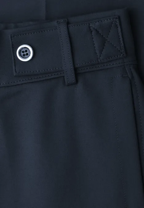 Nahaufnahme einer dunkelblauen Hose mit Gürtelöse und Knopfdetail.