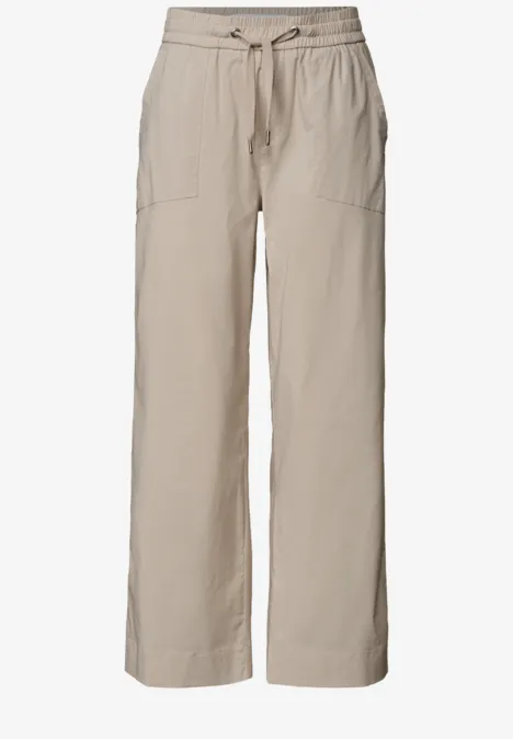 Helle, beige Leinenhose mit weitem Bein, Tunnelzugbündchen und aufgesetzten Taschen.