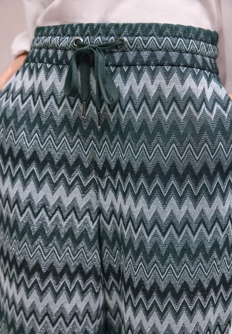 Broek met groen-grijs zigzagpatroon, elastische taille en trekkoord.