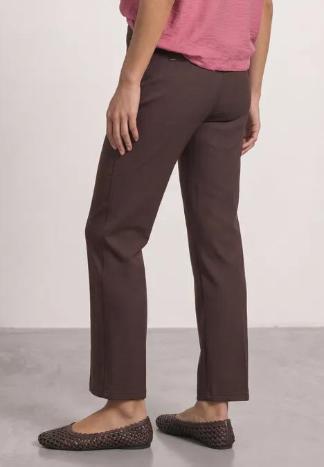 High Waist Straight Leg Hose im Casual Fit ruby vine Frau steht seitlich, trägt braune gerade Hose und flache Schuhe