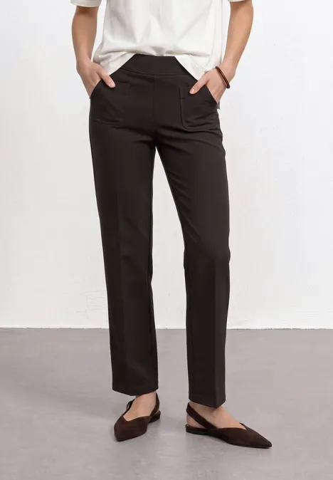 High Waist Straight Leg Hose im Casual Fit black coffee Schlanke schwarze Hose, weißes Oberteil, spitze Ballerinas, Hände in den Taschen.