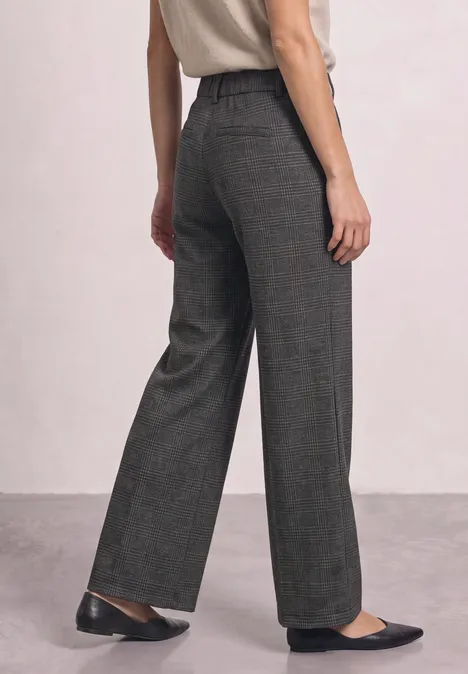 Dunkelgraue, weit geschnittene Stoffhose mit hohem Bund und schwarzen Ballerinas.