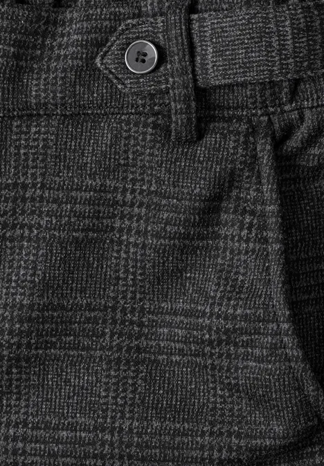 Nahaufnahme einer grauen Glencheck-Hose mit Gürtelschlaufen und Knopf