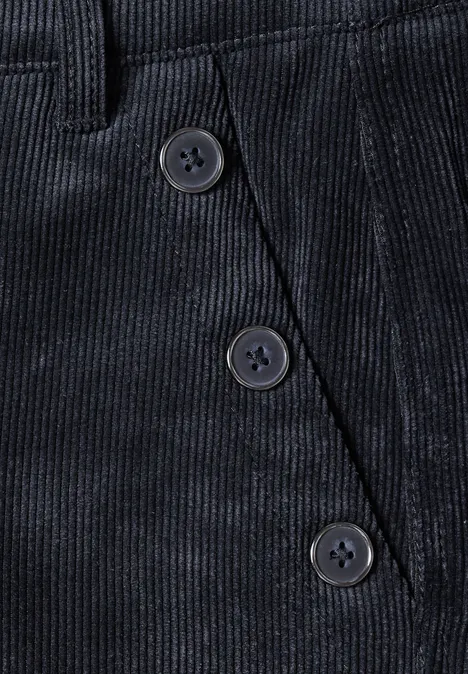 Close-up einer dunkelblauen Cordhose mit schräg verlaufender Knopfleiste