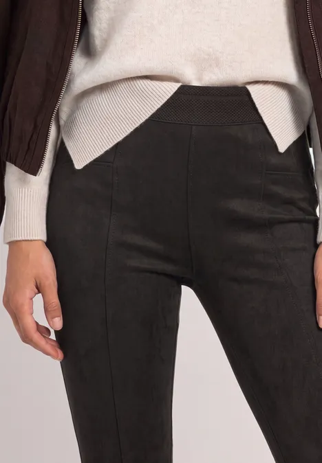 Schwarze, figurbetonte Leggings mit subtiler Naht vorne, kombiniert mit hellem Oberteil.