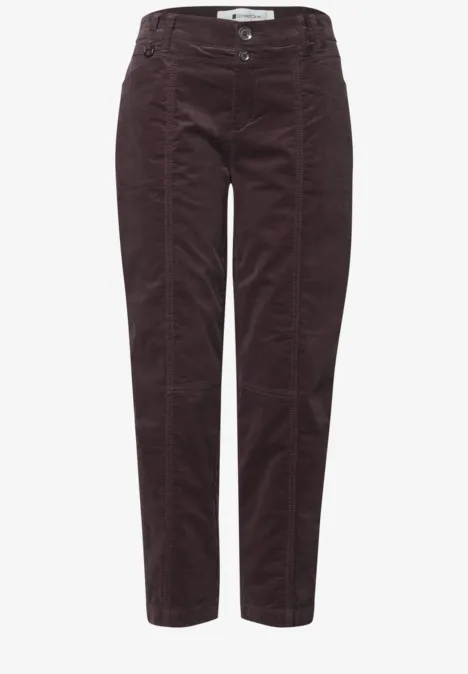 Weinrote Cordhose mit hoher Taille, sichtbaren Nähten und schmalem, leicht verkürztem Bein.