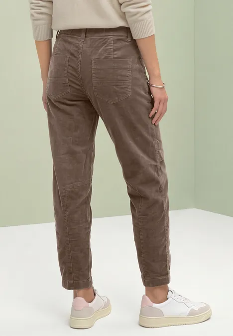 Barrel Leg-broek van corduroy in casual pasvorm velvet mocha Persoon van achteren in bruine corduroy broek en witte sneakers voor een lichte achtergrond.