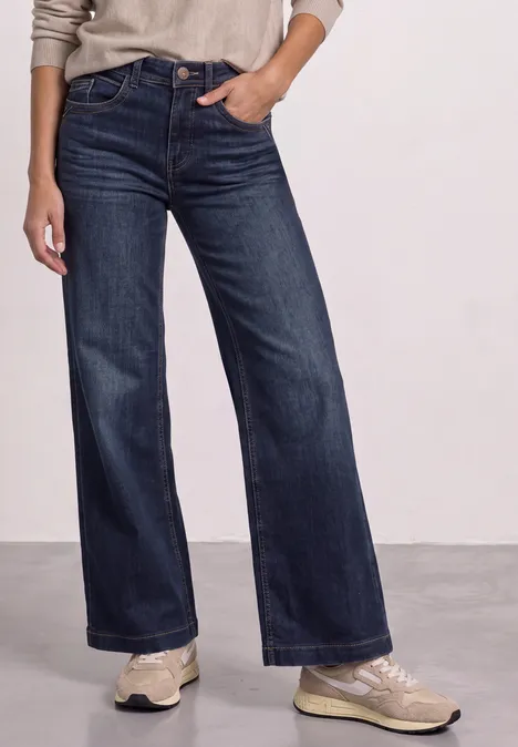 High Waist Wide Leg Jeans im Loose Fit Dark Blue Clean washed Person trägt weite dunkelblaue Jeans und helle Sneaker.