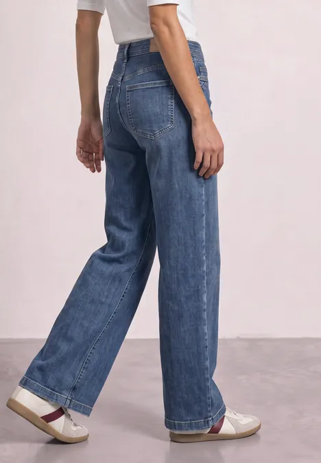 High Waist Wide Leg Jeans im Loose Fit Medium Blue Soft Washed Hoch taillierte, weite Jeans aus blauem Denim mit klassischem Beinschnitt und weißen Schuhen.