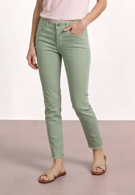 Grüne, schmale Damenhose, knöchellang, kombiniert mit einem hellen Oberteil und Sandalen.