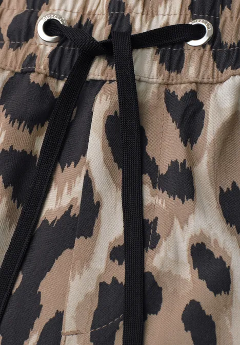 Beige-schwarzer Animal-Print-Stoff mit elastischem Bund und schwarzer Kordel durch silberne Ösen.