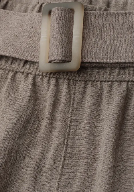 Detail eines beigen Leinenbunds mit eingenähtem Gürtel und passender rechteckiger Schnalle