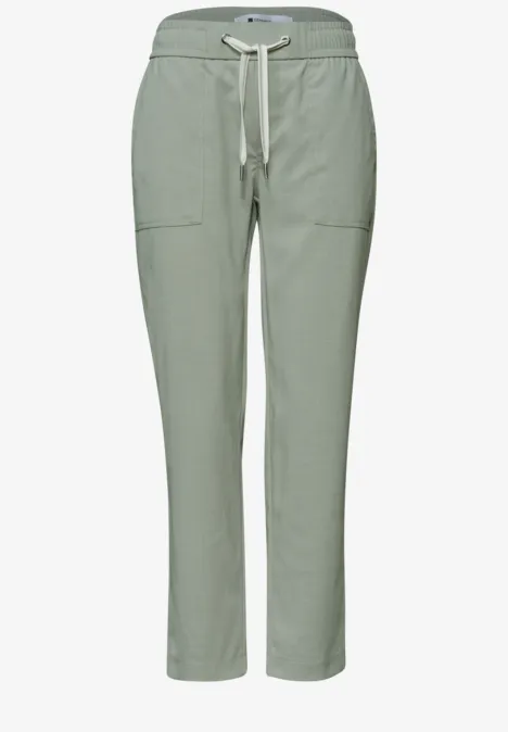 Lichte saliegroene broek met elastische taille, aantrekkoord en opgestikte zakken – comfortabel en casual.