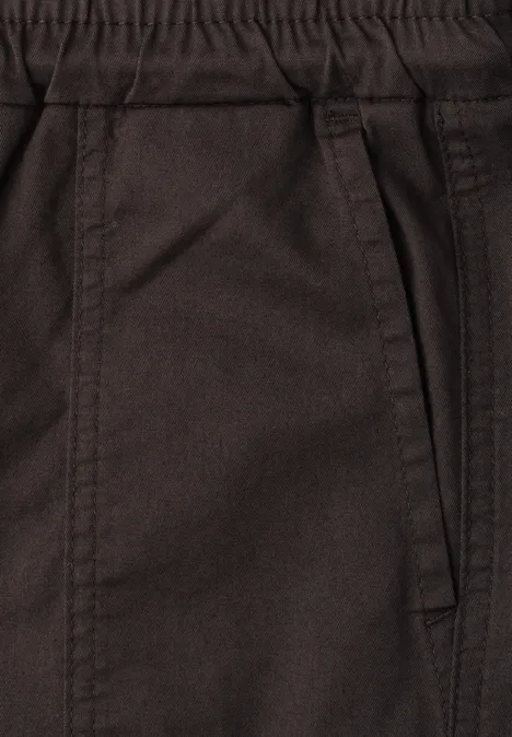 Nahaufnahme einer braunen Hose mit elastischem Bund und seitlicher Tasche.