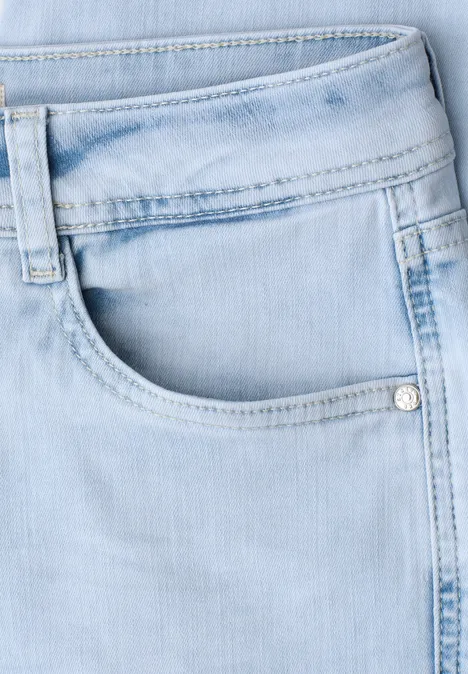 Nahaufnahme einer hellblauen Jeans mit vorderer Hosentasche und Gürtelschlaufe.