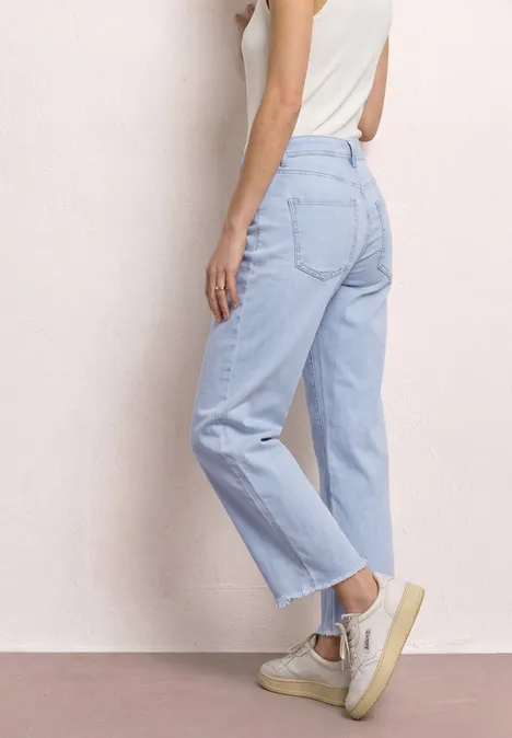 Zijaanzicht van een vrouw in lichtblauwe, rechte jeans met hoge taille.