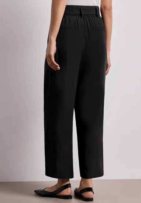 Schwarze, weite, knöchellange Hose mit hohem Bund aus leicht strukturiertem Stoff.