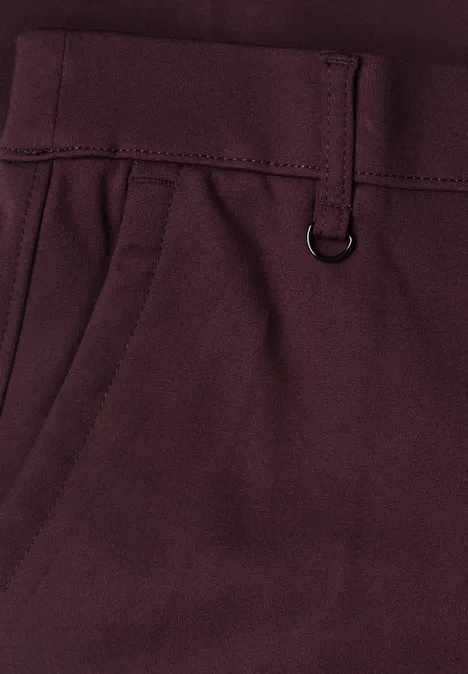 Nahaufnahme einer bordeauxfarbenen Hose mit Blick auf Gürtelschlaufe, D-Ring und Seitentasche.