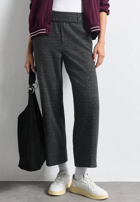 Graue Bügelfaltenhose im Karomuster, weiße Sneakers und schwarze Stofftasche, legerer Streetstyle.