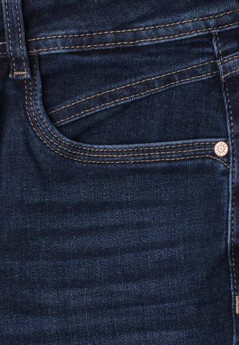 Nahaufnahme einer dunkelblauen Jeans mit sichtbarer Tasche und Nahtdetails.