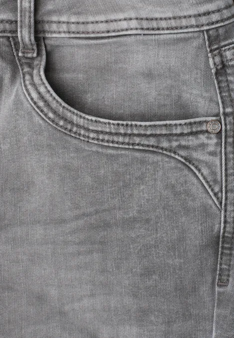 Nahaufnahme einer grauen Jeans mit sichtbarer Tasche und markanten Nähten.