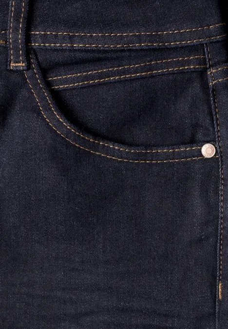 Nahaufnahme einer dunkelblauen Jeanshose mit seitlicher Tasche, goldenen Nähten und Metallniete.