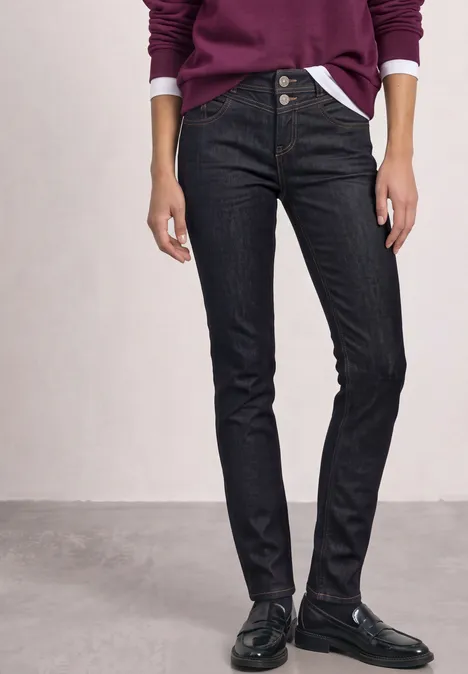 Mid Waist Slim Leg Jeans w Casual Fit Deep Rinse Washed Czarne obcisłe jeansy z wysokim stanem, noszone z czarnymi mokasynami i fioletowym swetrem.