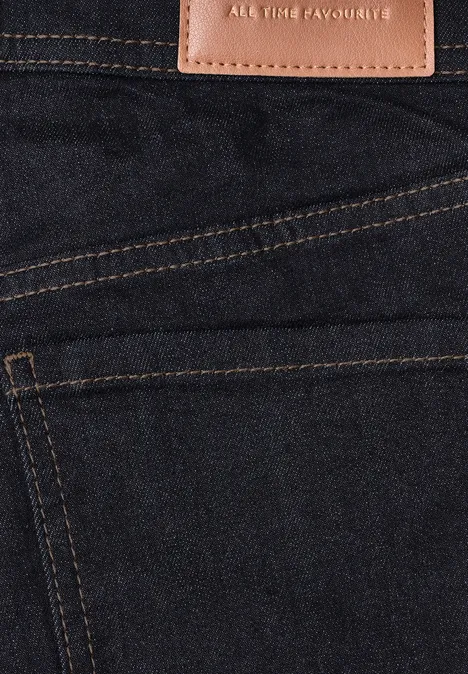Mid Waist Slim Leg jeans w kroju Slim Fit Deep Rinse Washed Zbliżenie na ciemne dżinsy z widocznym przeszyciem i skórzaną metką 'All Time Favourite'.