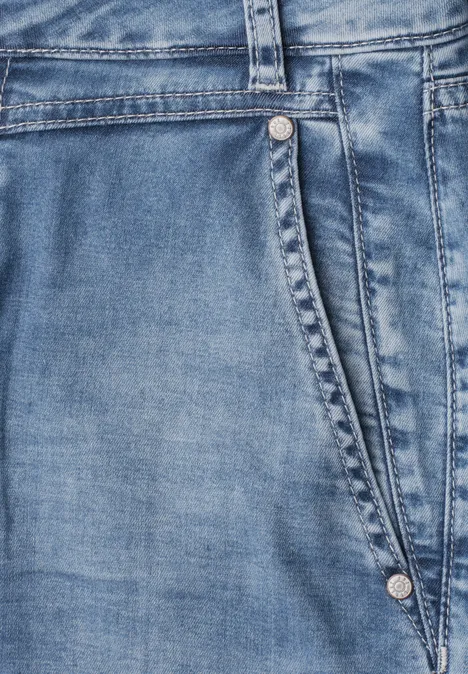 High Waist Barrel Leg Jeans im Loose Fit Medium Blue Random Wash Nahaufnahme einer hellblauen Jeanshose mit sichtbarer Seitentasche und Metallnieten.