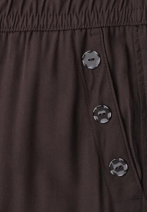 Pantalon brun foncé à taille élastique et trois boutons-pression sur le côté.