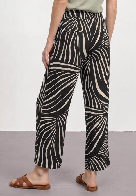 7/8 Wide Leg Hose im Loose Fit Black Weite schwarz-weiße Hose mit Zebramuster, getragen von Person mit braunen Sandalen.