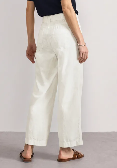 Straight Leg Hose in Washed-Optik off white Person von hinten, trägt weiße, weite 7/8-Hose mit hohem Bund und braune Sandalen.