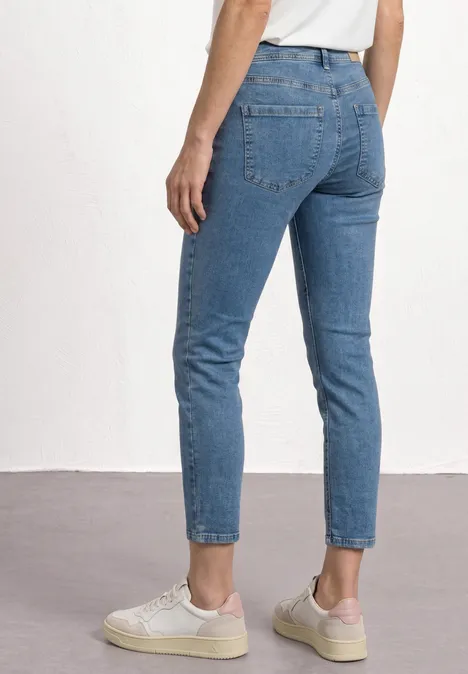 Straight Leg Jeans mit aufgesetzten Taschen Medium Blue Random Wash Eine Person trägt blaue Jeans und helle Sneaker, Rückansicht bis zur Hüfte.