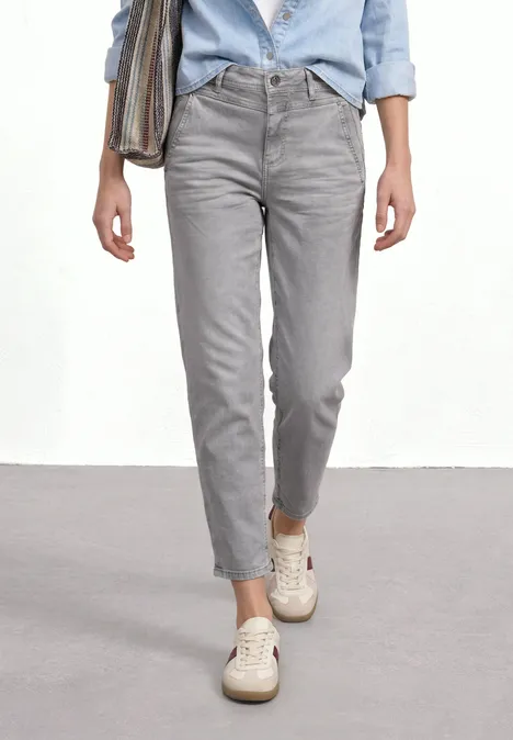 High Waist Barrel Leg Jeans im Loose Fit Light Grey Random Person trägt graue Jeans, hellblaues Hemd und weiße Sneaker, Hosenbeine umgekrempelt.