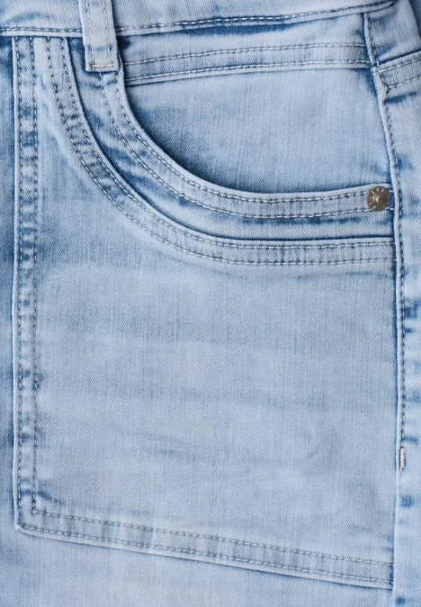 Gros plan sur une poche de jean bleu clair avec un subtil effet délavé.